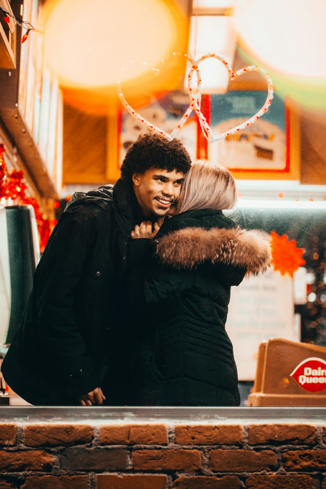 man in black jacket hugging woman in black fur coat