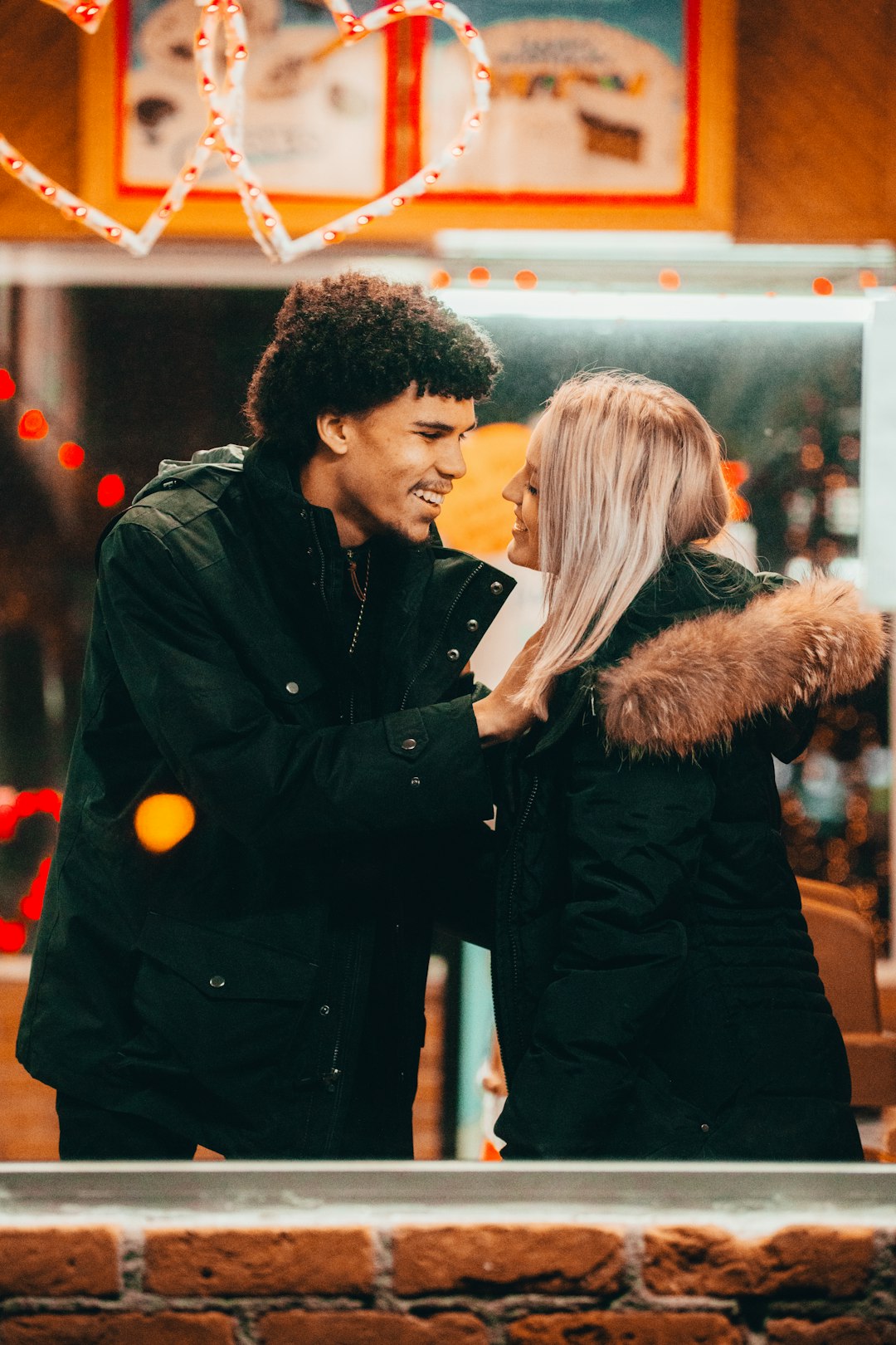 man in black leather jacket standing beside woman in black fur coat