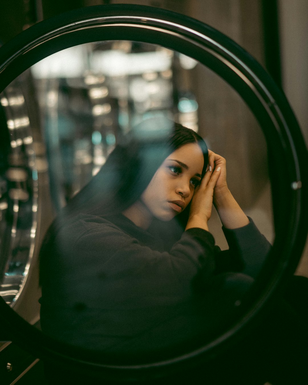 woman in black long sleeve shirt looking at mirror