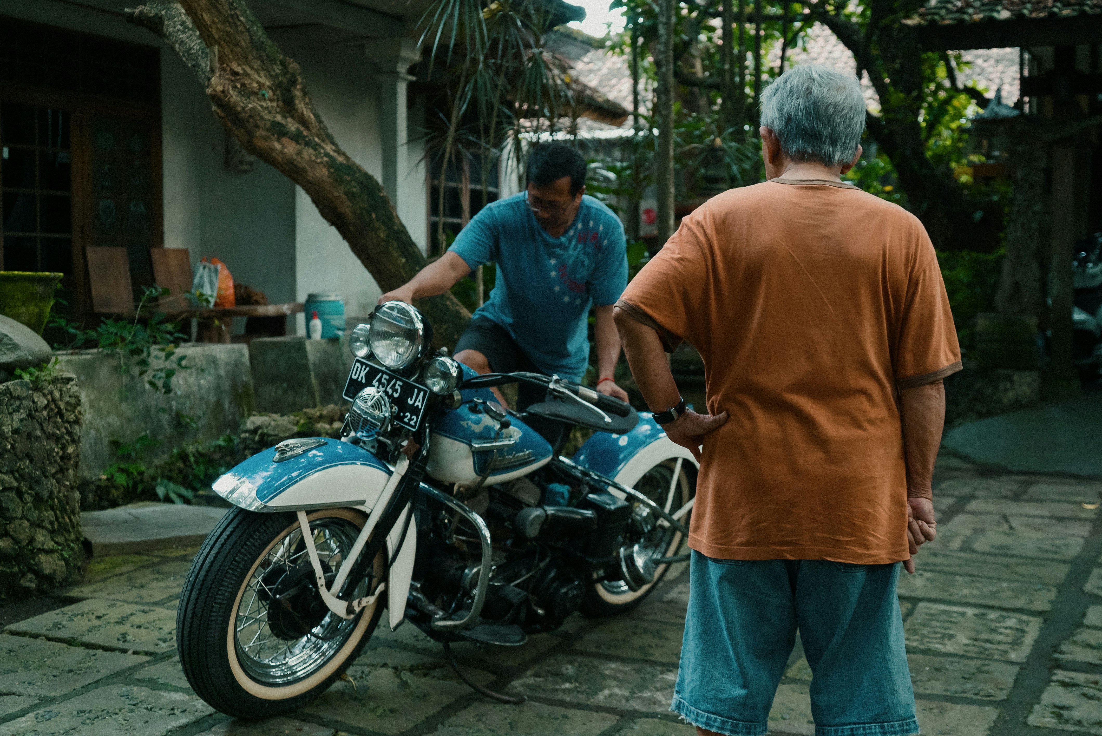 man in orange polo shirt standing beside man in orange polo shirt