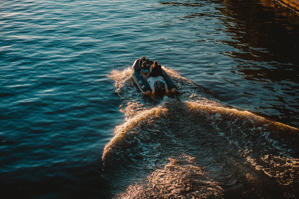 man in black wetsuit lying on white surfboard on body of water during daytime