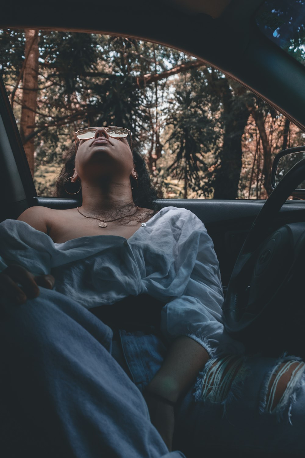 woman in white dress shirt driving car