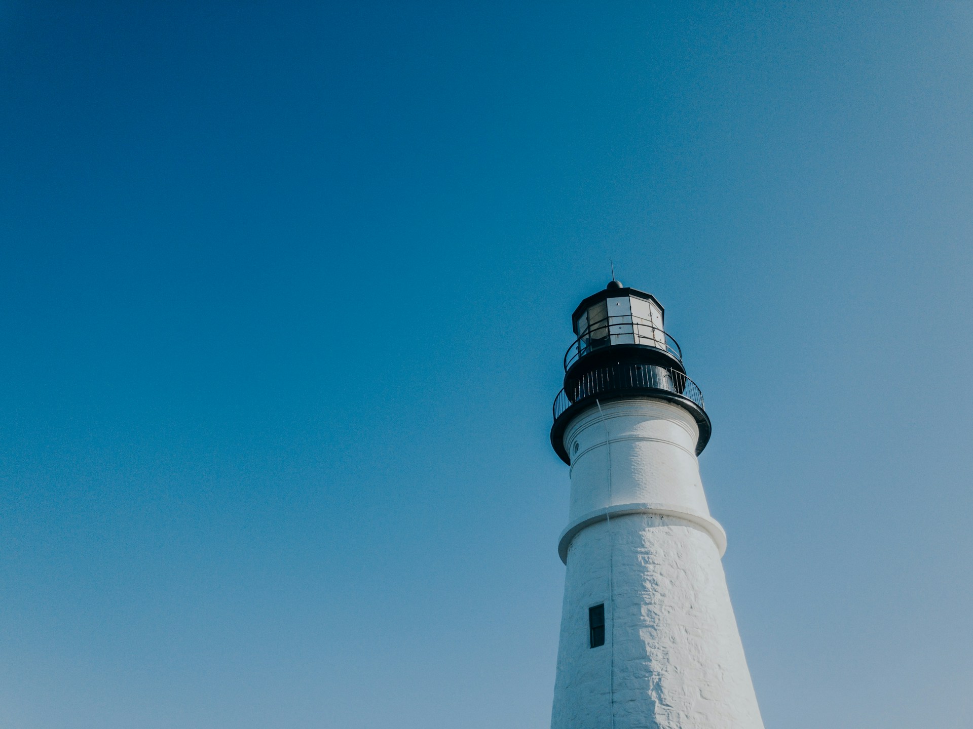 white and black lighthouse under blue sky during daytime