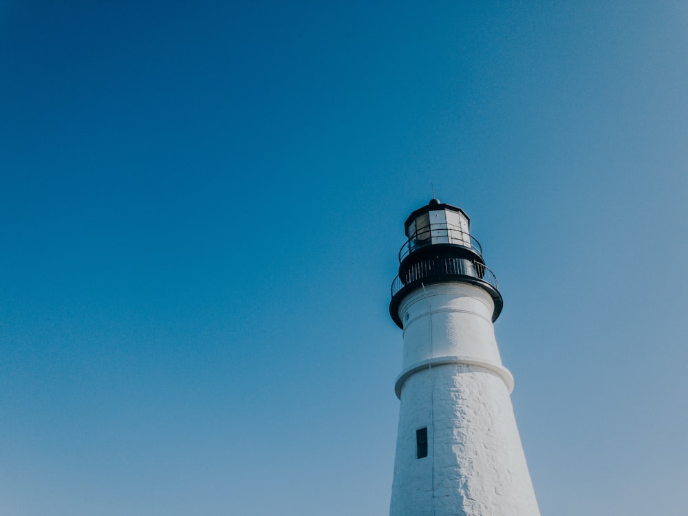 white and black lighthouse under blue sky during daytime