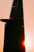 A sleek high-rise tower under construction in Dubai, bathed in golden sunset light.