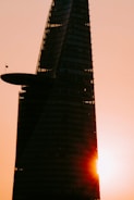 Architectural rendering of a sleek hotel tower rising above Cairo skyline at sunset.