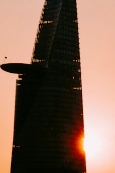 A sleek, modern skyscraper bathed in golden sunset light, symbolizing strength and luxury.