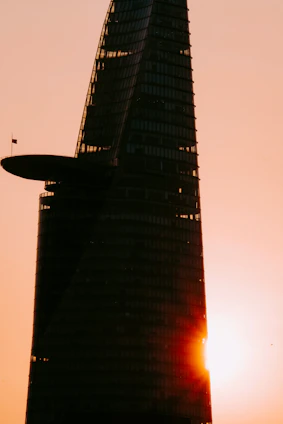 A sleek, modern high-rise building bathed in golden sunset light, symbolizing luxury real estate in the UAE.