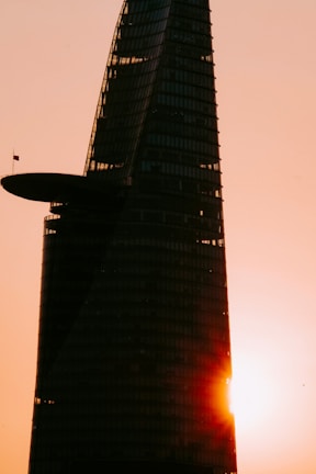 A sleek high-rise tower under construction in Dubai, bathed in golden sunset light.