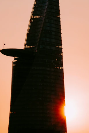 A sleek, modern skyscraper in Baghdad reflecting the dawn light, symbolizing growth and opportunity.