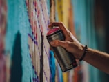 A close-up of a painter applying a vibrant color to a wall.