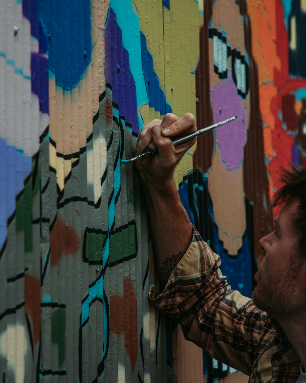 man in brown and black plaid button up shirt smoking cigarette