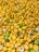 A large collection of yellow Lego minifigure heads, some with facial expressions or accessories like glasses. The heads are predominantly yellow, with occasional green and white ones mixed in.