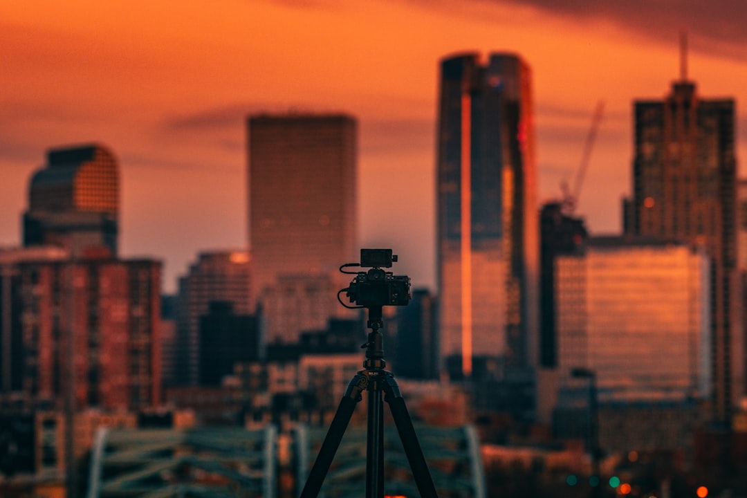 black camera on tripod in front of city buildings during daytime