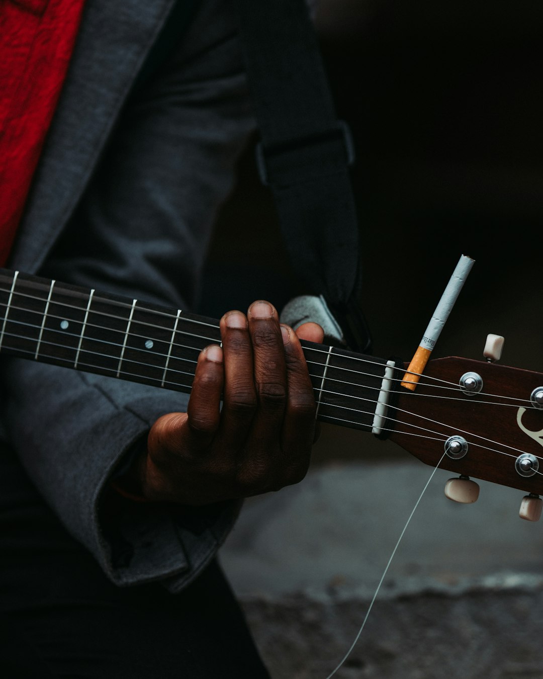 man in black suit playing guitar