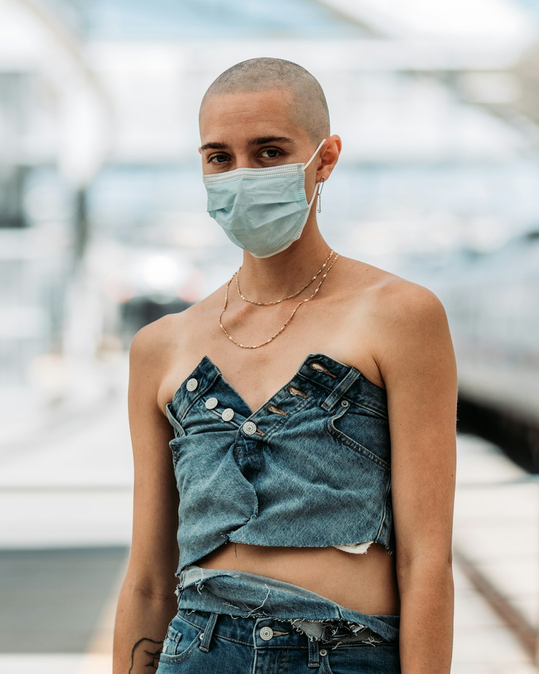 woman in blue denim button up sleeveless shirt wearing white face mask