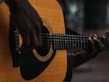 A close-up of a musician playing an acoustic guitar.