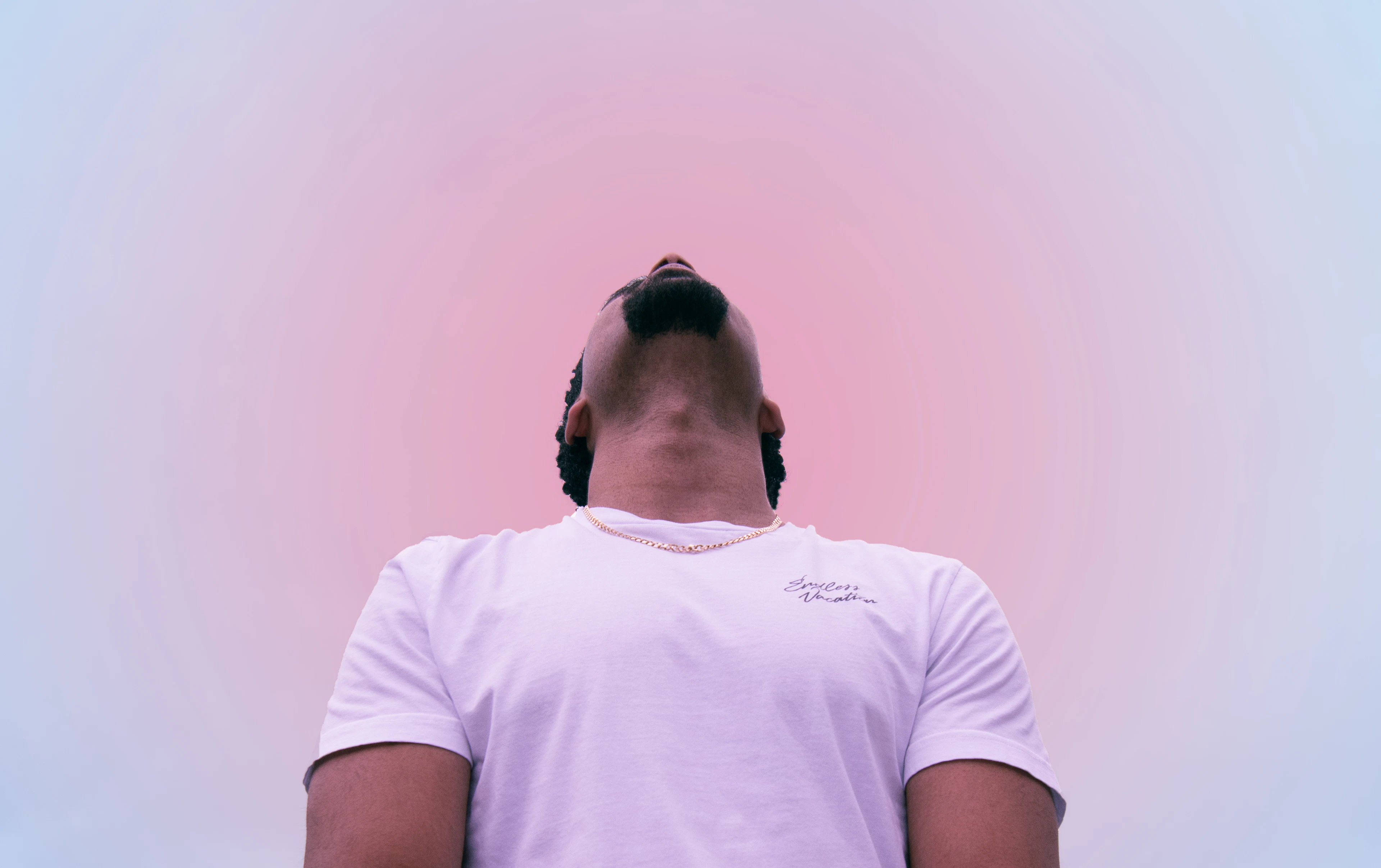 Pessoa com camiseta lilás clara contra um fundo em degradê