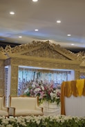 A beautifully decorated wedding stage with fresh floral arrangements and elegant drapes.