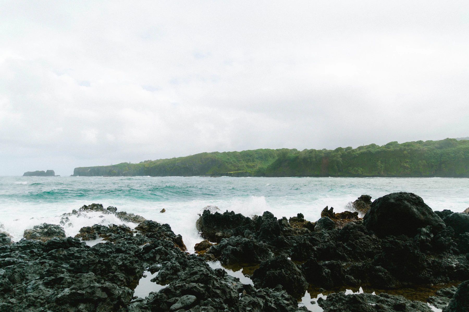 Black rocks along the shoreline on the road to Hana