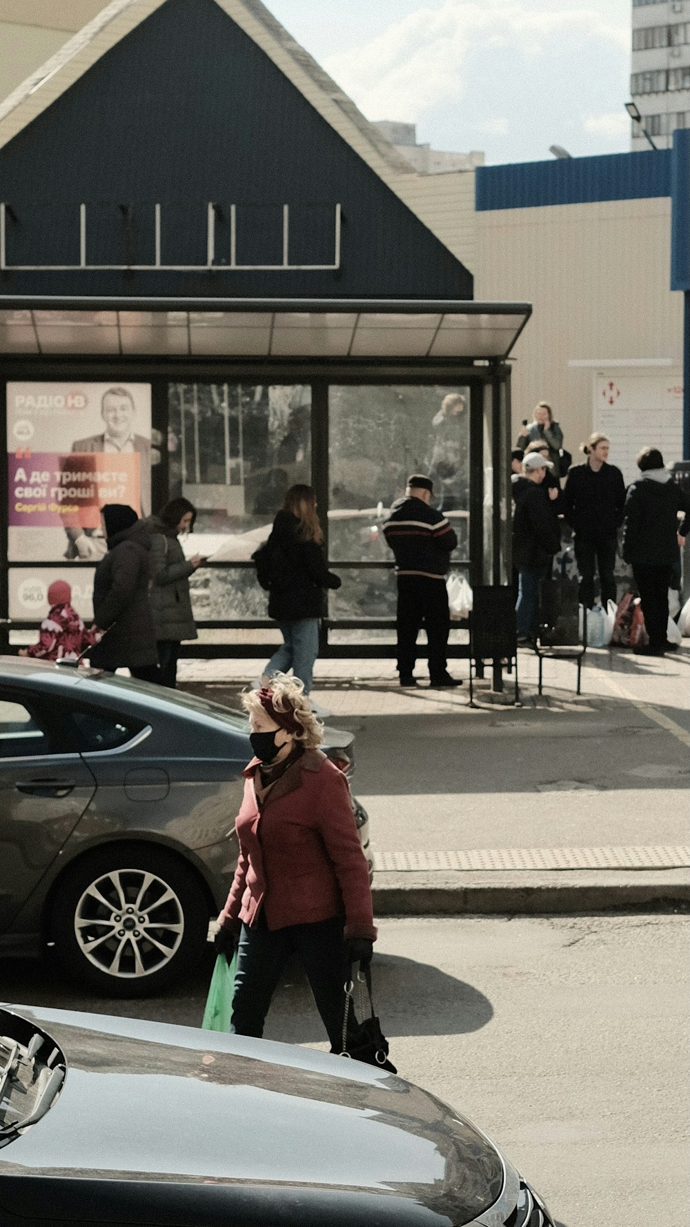 woman in red coat standing near black car during daytime