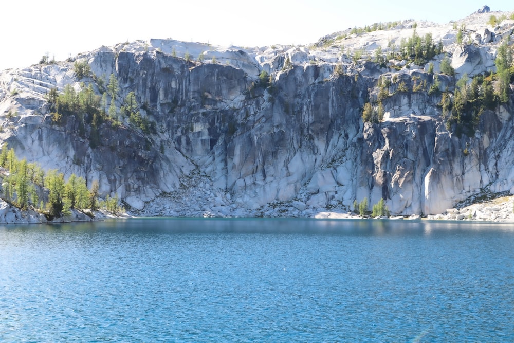 gray and white rocky mountain beside blue sea during daytime