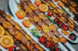 grilled meat with sliced orange and green vegetable on white ceramic plate