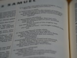 Pages of an open book featuring text in English. The text includes sections that seem to be from a literary or religious text, focusing on poetic or narrative forms.