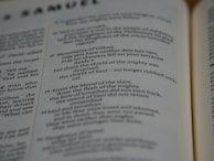 Pages of an open book featuring text in English. The text includes sections that seem to be from a literary or religious text, focusing on poetic or narrative forms.