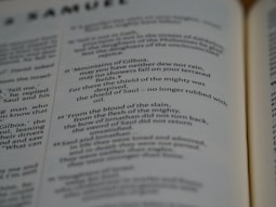 Pages of an open book featuring text in English. The text includes sections that seem to be from a literary or religious text, focusing on poetic or narrative forms.