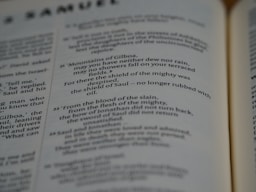 Pages of an open book featuring text in English. The text includes sections that seem to be from a literary or religious text, focusing on poetic or narrative forms.