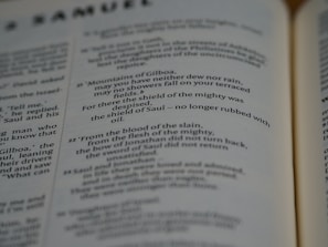 Pages of an open book featuring text in English. The text includes sections that seem to be from a literary or religious text, focusing on poetic or narrative forms.