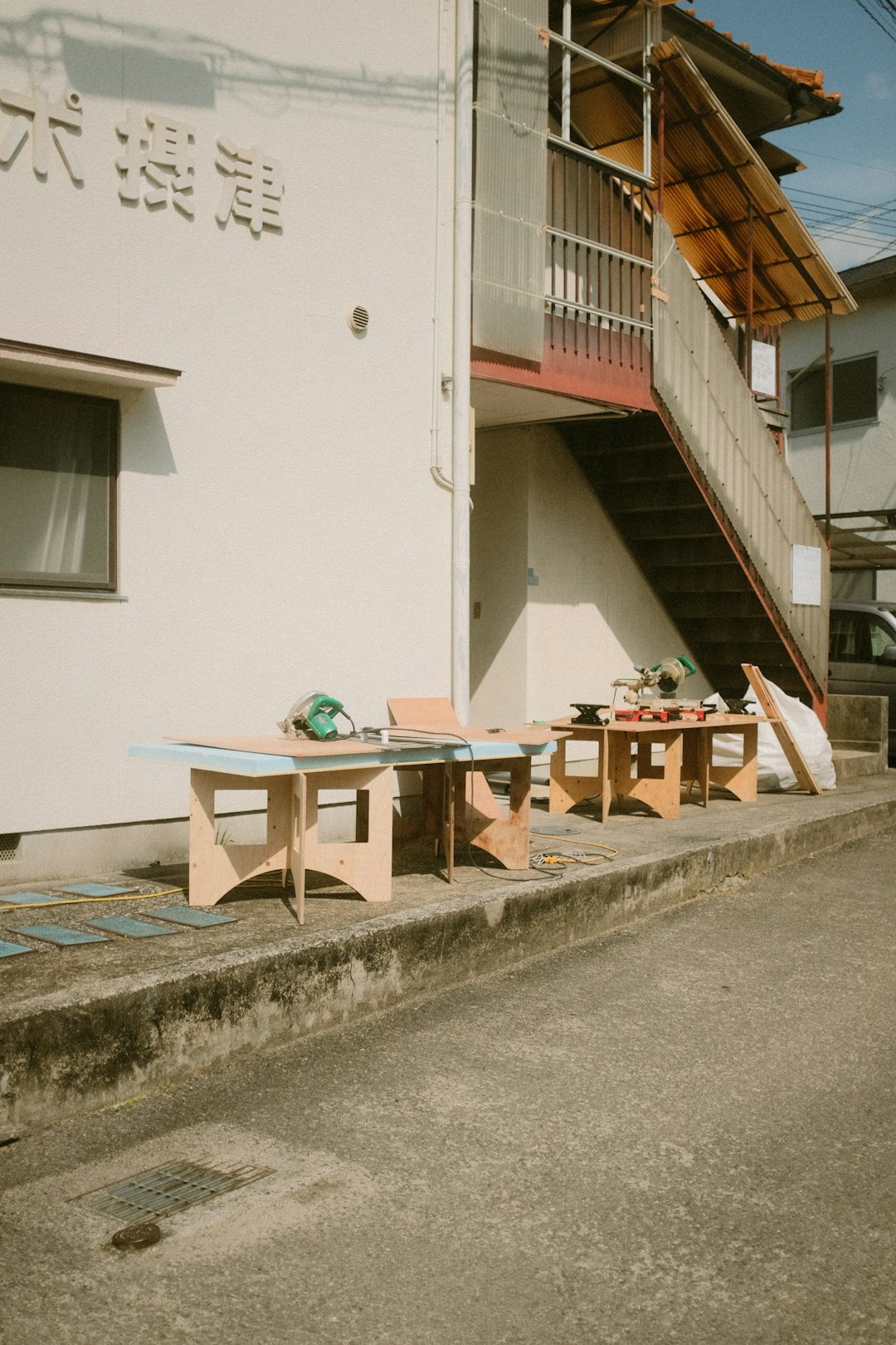 brown wooden table and chairs near white concrete building