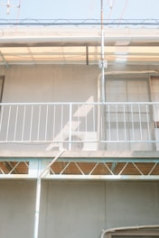 HVAC technician repairing an air conditioning unit on a residential balcony.