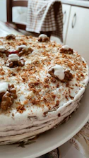 A warm, inviting photo of a freshly baked homemade cake with creamy frosting on a rustic wooden table.