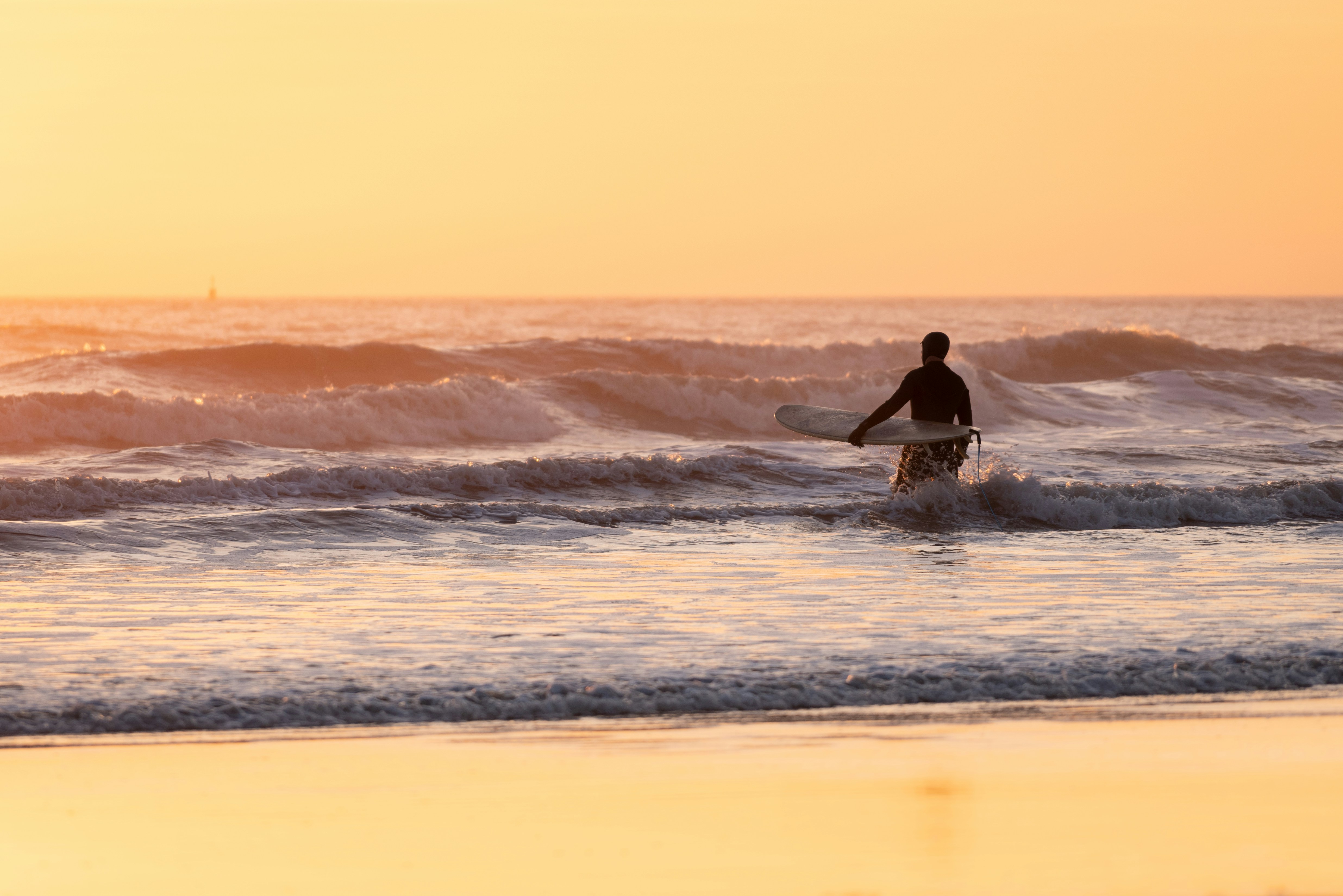 man surfing on sea waves during sunset