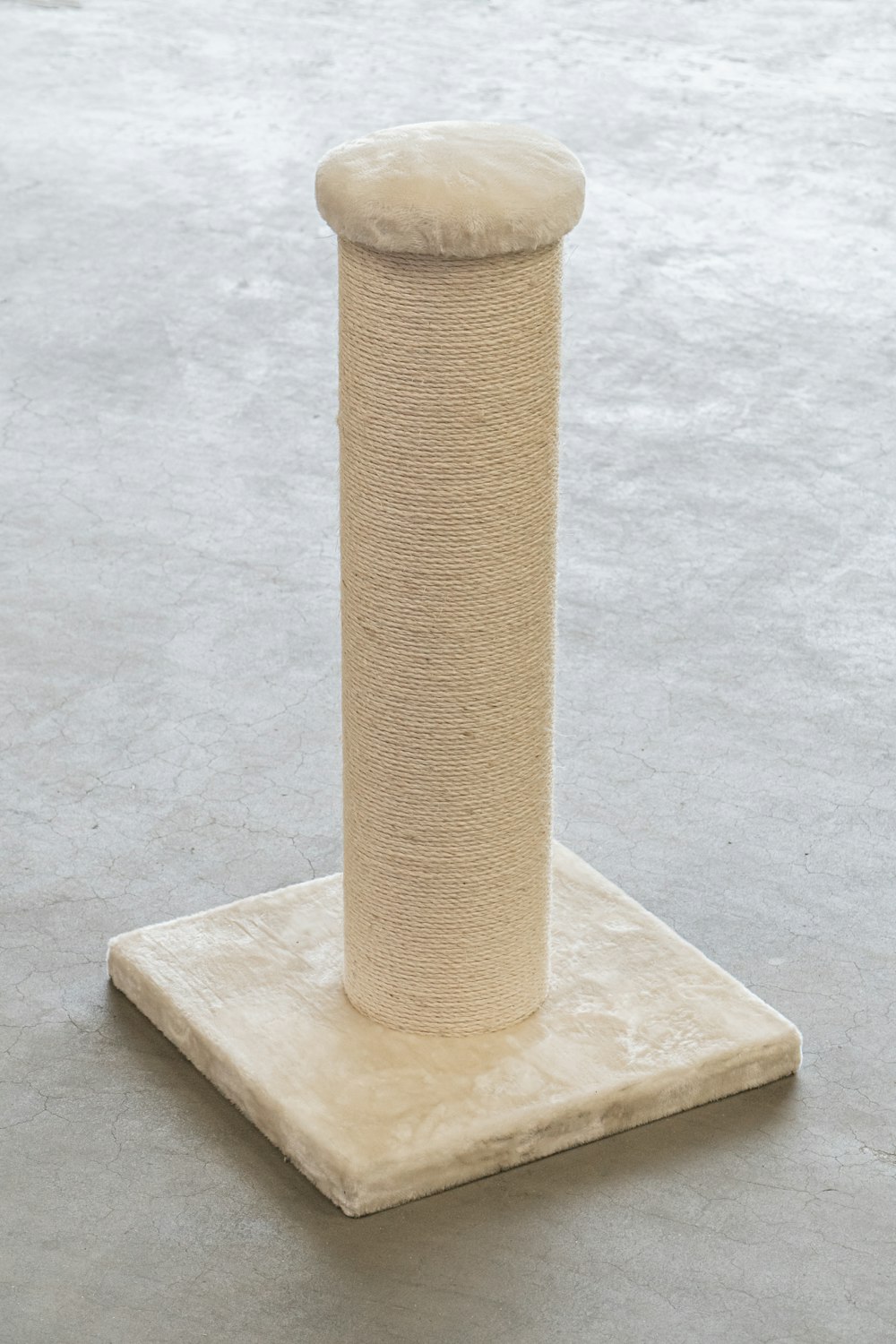 pilastro di legno marrone su pavimento di cemento grigio