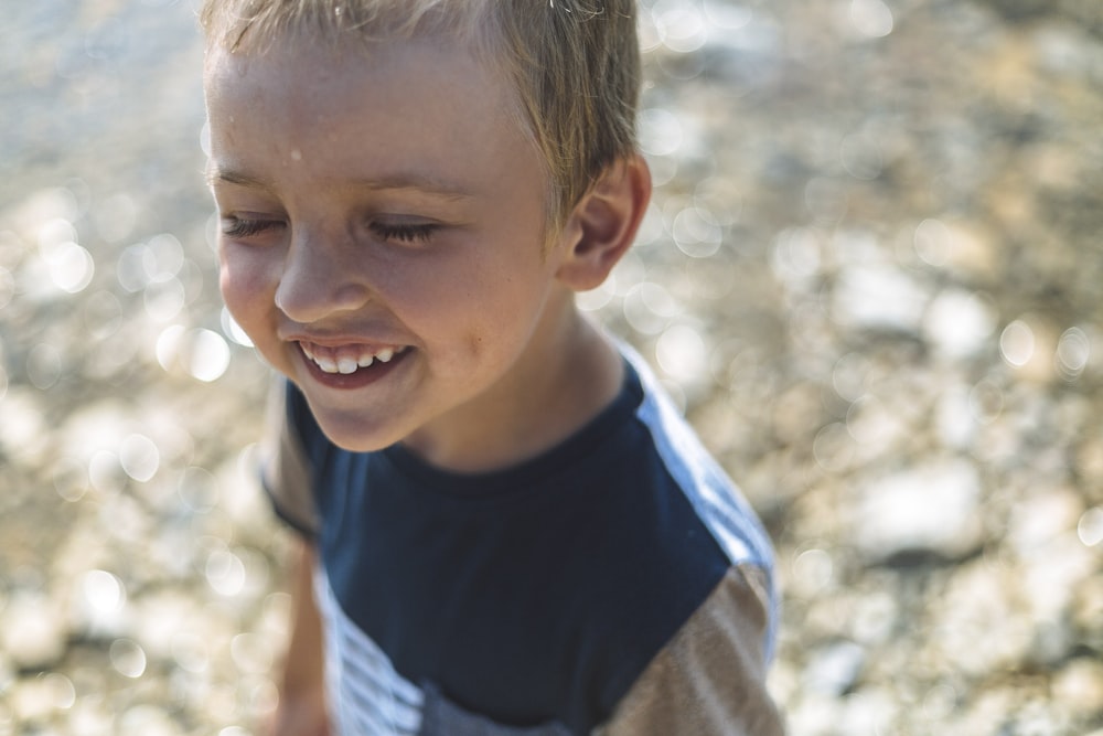 Junge im blau-weißen Rundhalshemd lächelnd