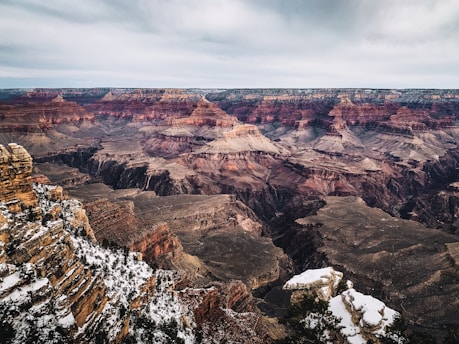 brown and white rocky mountain under gray sky