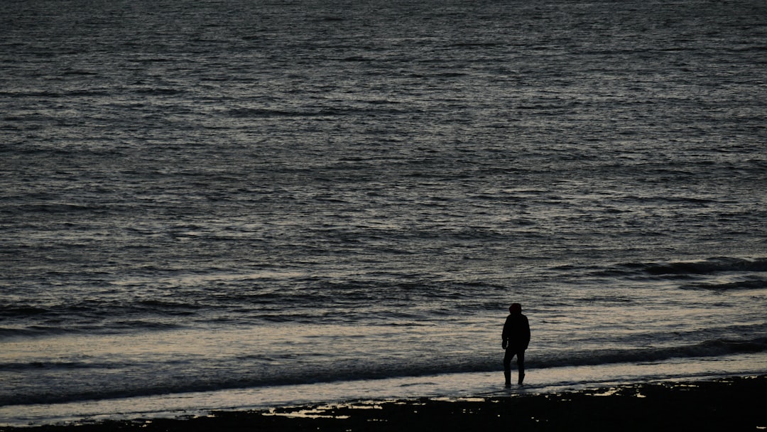 man standing on beach shore during daytime