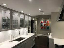 Before and after shots of a kitchen remodel showcasing sleek cabinetry and bright finishes.