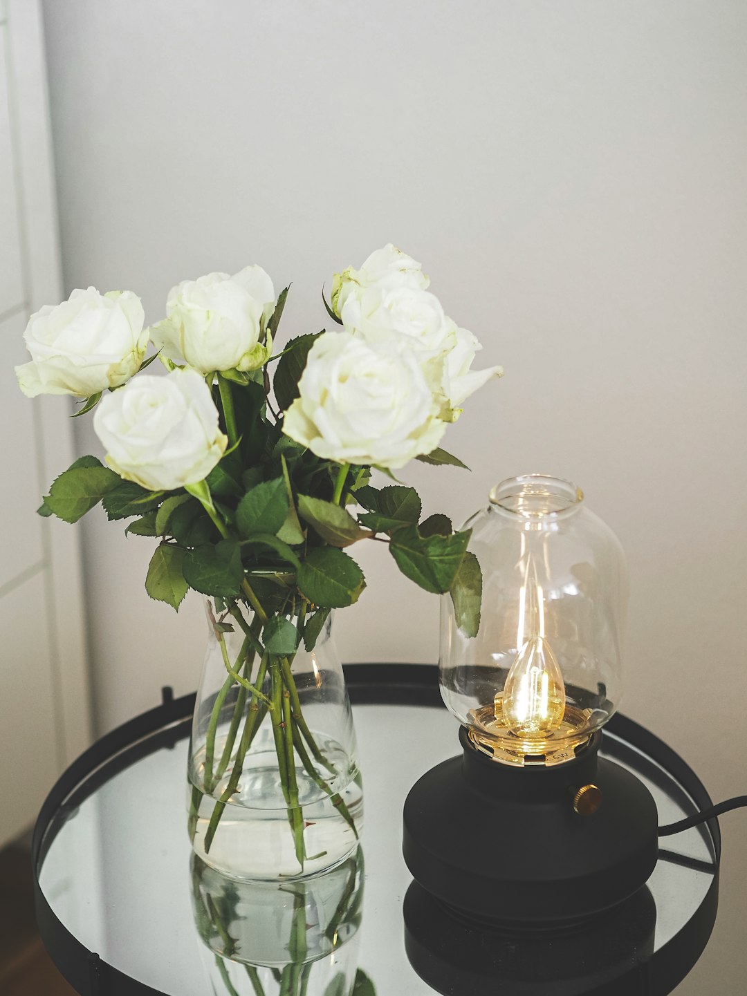 white roses in clear glass vase