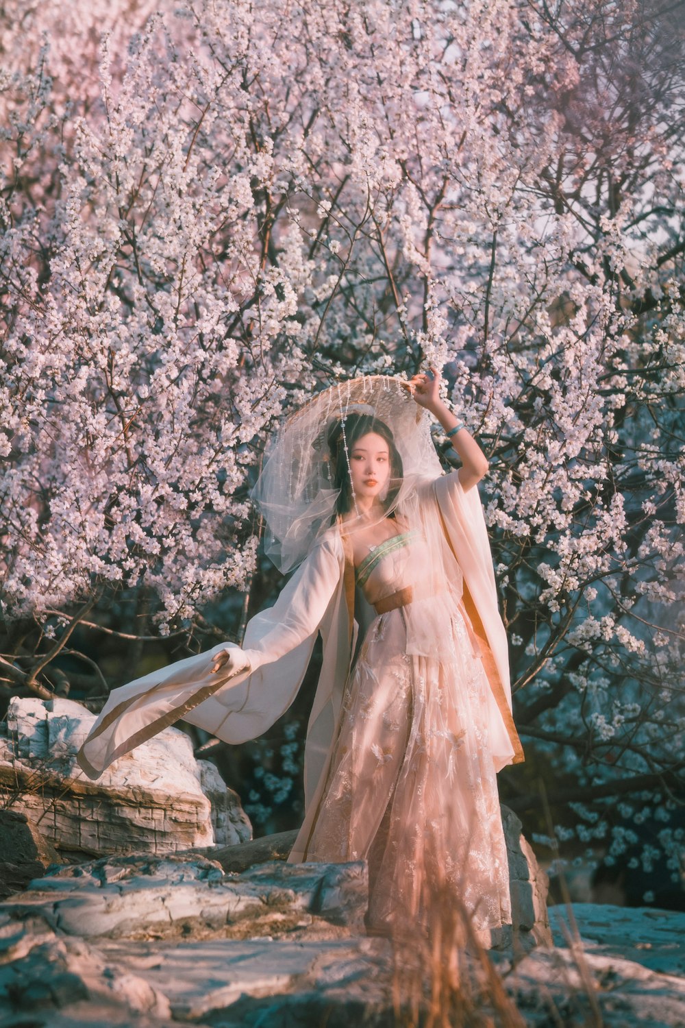 woman in white dress standing on rock