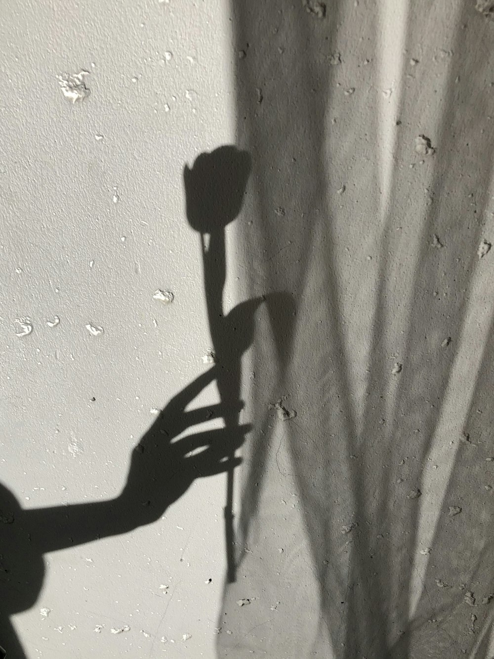 ombre d'une personne sur un mur blanc