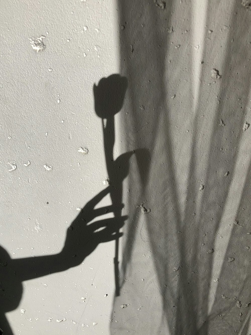 Schatten der Person an weißer Wand