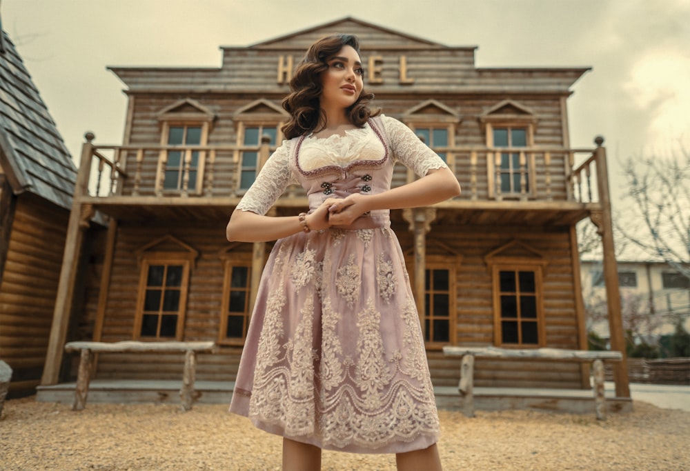 woman in white and pink floral dress standing on brown sand during daytime