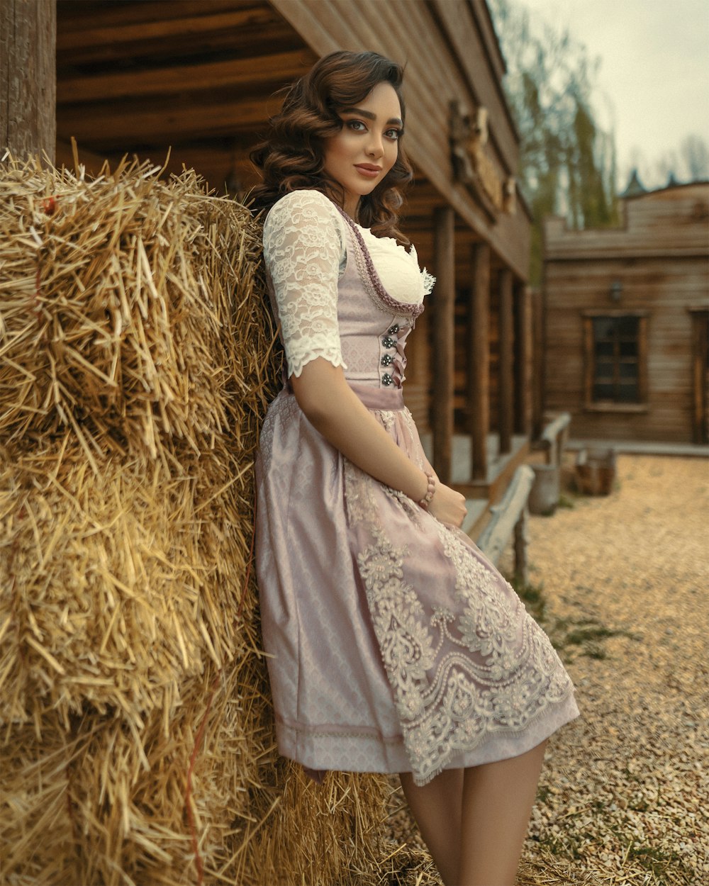 girl in white dress sitting on brown hay