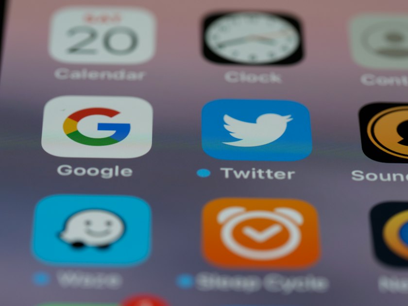 iPhone home screen close-up showing app icons in detail, representing the constant pull of notifications in the reply economy