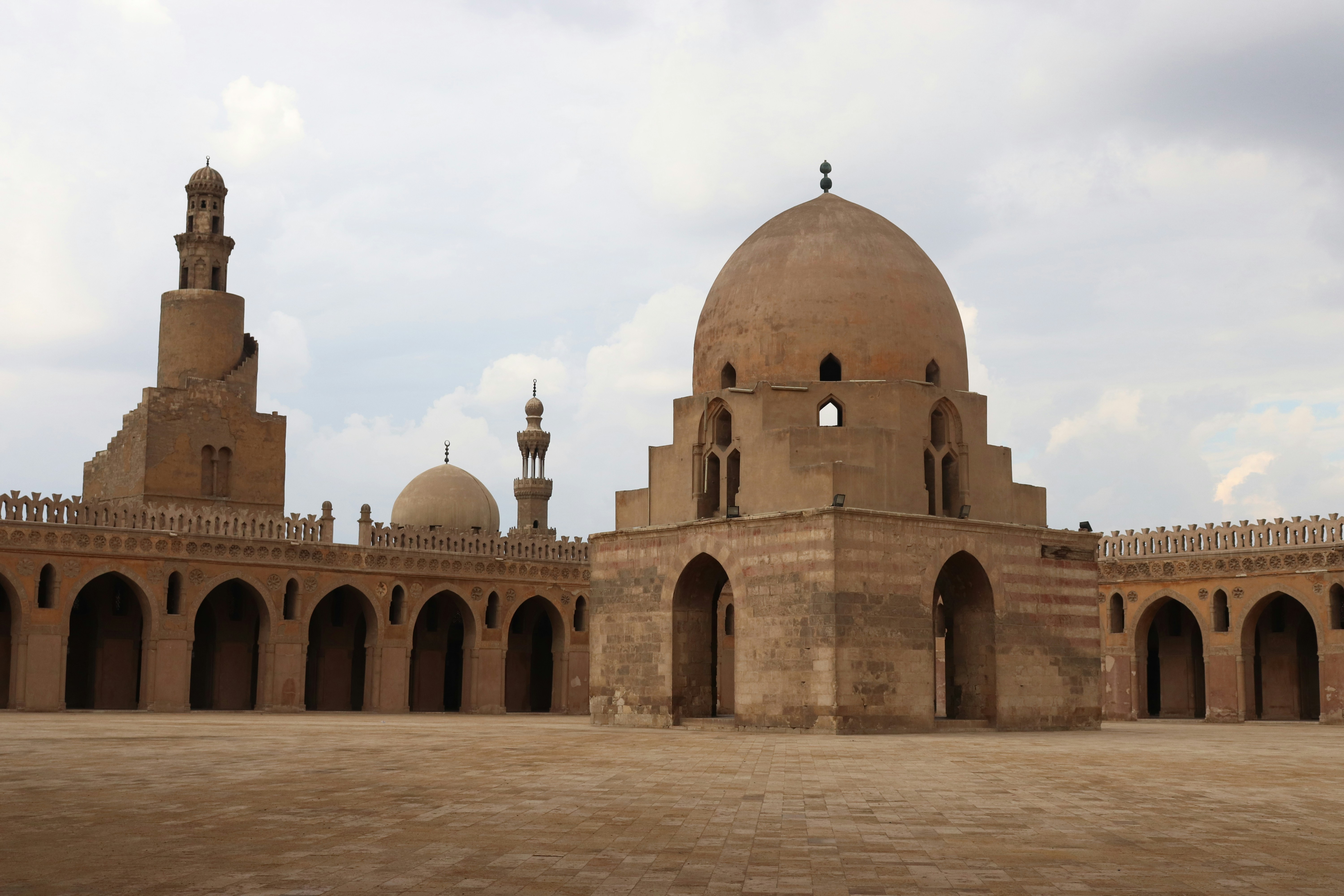 Brown concrete dome building under white sky during daytime