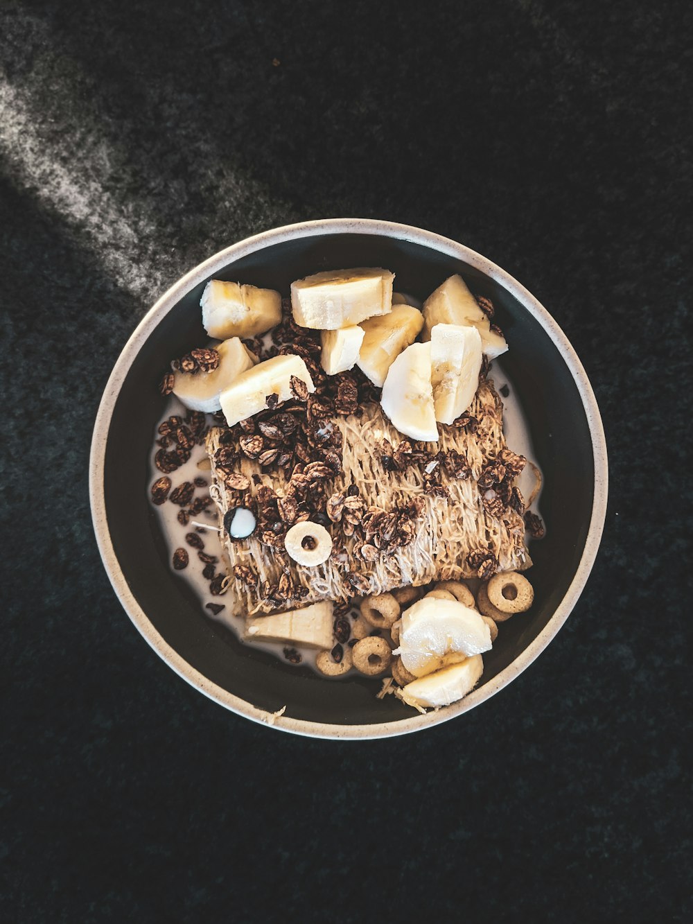 sliced banana in black and white ceramic bowl